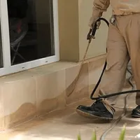 General pest control technician spraying exterior perimeter around a home in Pittsburgh, PA